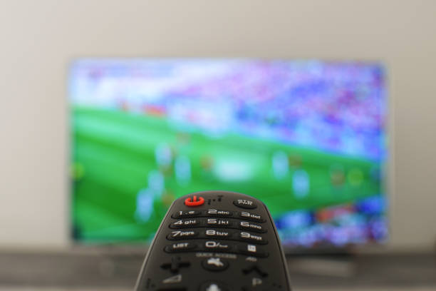 istock Whatching football concept Remote controll with blured tv on th background 993747670