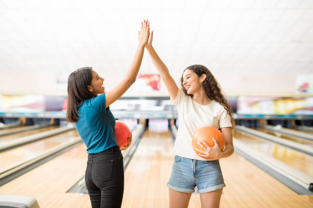 女の子ボウリング ゲームを開始する前に高い 5 を与える - bowling holding bowling ball hobbies ストックフォトと画像