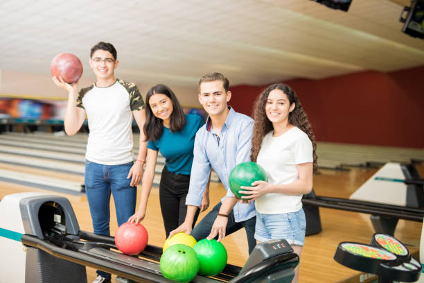 istock Friends Picking Up Balls While Hanging Out At Bowling Alley 993760356