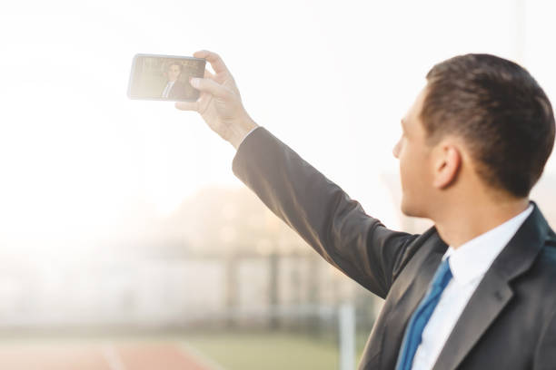 istock Businessman making selfie looking to his image on the screen 993760714