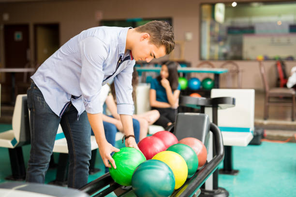 istock Boy Picking Up Bowling Ball From Rack In Club 993760738
