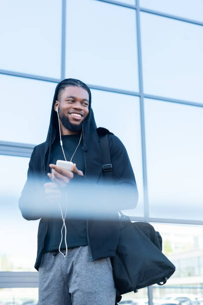 istock selective focus of smiling african american man using smartphone and looking away 993760756