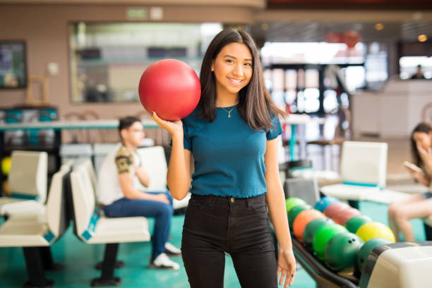 teenager-mädchen mit roten bowling ball im club - bowling holding bowling ball hobbies stock-fotos und bilder