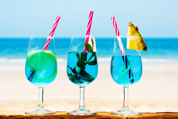 istock Blue cocktails against seaside background 993789762