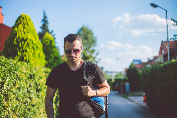 Young man with backpack walking outdoor.