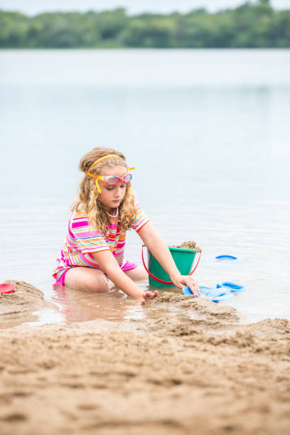 istock Young Girl Playing In Sand and Water at Beach 993799222