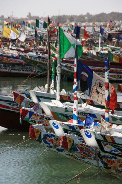 centenas de colorido pintadas pirogas atracado no cais do pescador de saint-louis-du-senegal - senegal flag dirty africa - fotografias e filmes do acervo