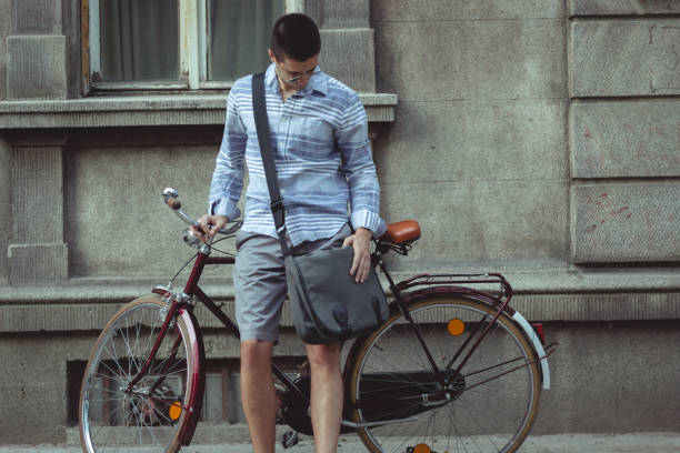 istock Casually dressed man looking at the ground while leaning against his retro bicycle 993954842
