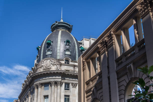 Close up of building dome and metal green sculpture of yound man sitting on an eagle with spread wings on a beautiful summer day on Passeig de Gràcia street in the Eixample district, Barcelona, Spain, Europe.