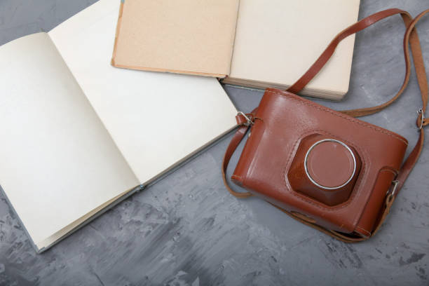 istock Vintage camera in the case and old open books 993961332