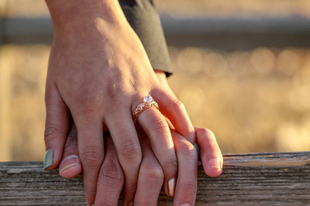 istock Newly Engaged Couple Holding Hands on Wood Plank 993962542