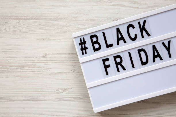 istock Black friday word on lightbox over white wooden surface, top view. Copy space. 993963154