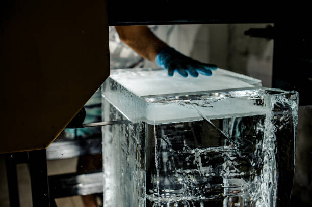 istock Man cutting a big ice cube with a special tool on the plant 993963620