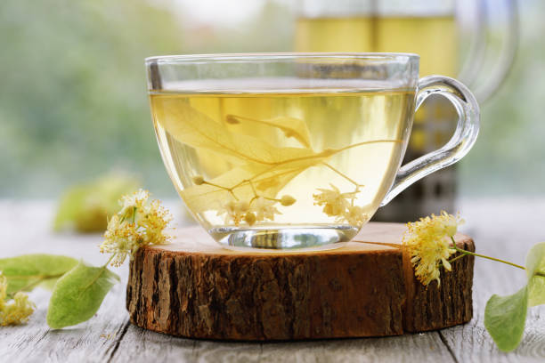 Cup of fresh tea from linden leaves in transparent dishes on a wooden stand, close-up stock photo
