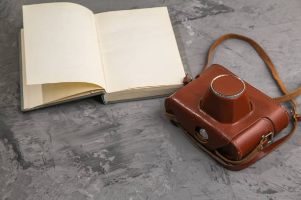 istock Vintage camera in the case and old open book 993965072