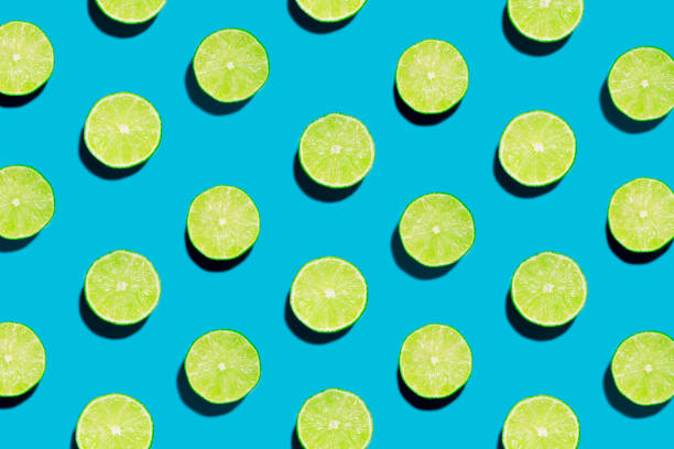 istock Sliced Open Geen Limes on Symmetrical Blue Background with one peeled open 993965926