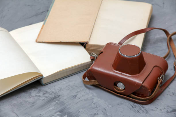 istock Vintage camera in the case and old open books 993966124