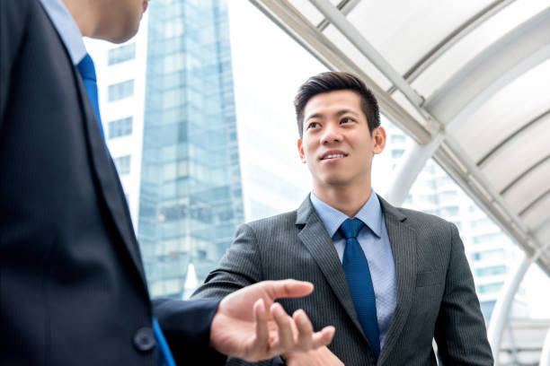 istock Young handsome Asian Chinese businessman talking with partner 993970032