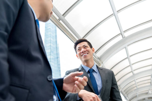 istock Young handsome Asian Chinese businessman talking with partner 993970036