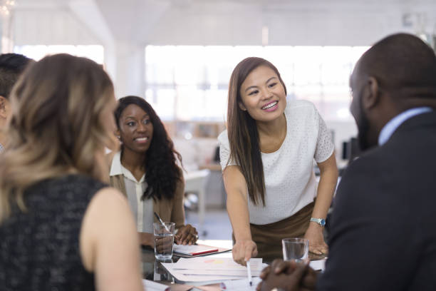istock Female CEO leads a team meeting at the conference table 993970248