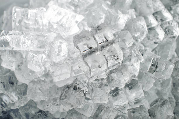 Textured background of a small ice cubes Textured background of a small clear ice cubes in the heap on the ice production plant ice machines stock pictures, royalty-free photos & images