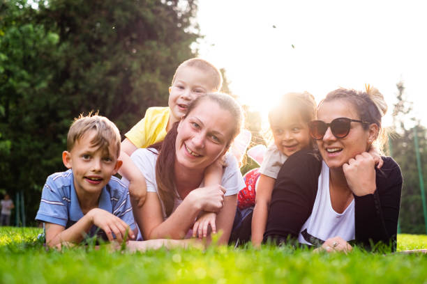 istock Happy people lying down on grass and looking at camera 993978538