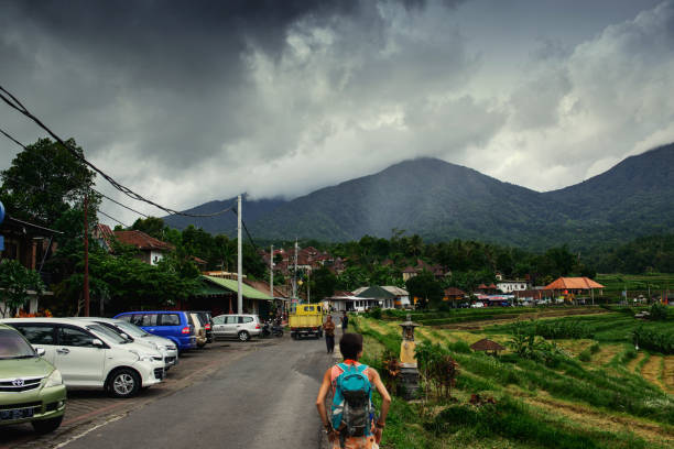 North Kuta, Bali, Indonesia - December 20, 2015 -Girl on the road looking at the mountain