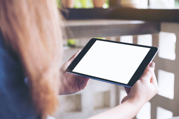 istock Mockup image of a woman holding black tablet pc with blank white desktop screen in cafe 994020536
