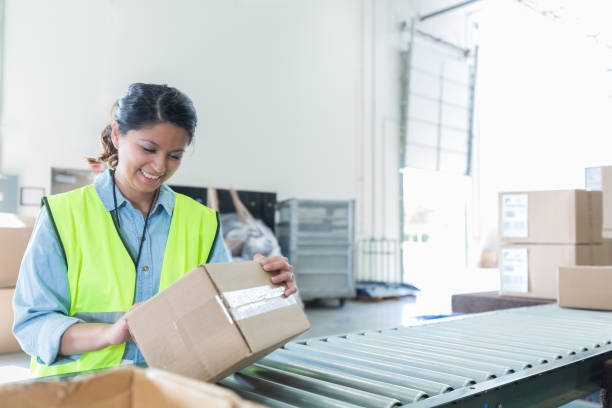 istock Confident woman attaches label to package in distribution warehouse 994021448