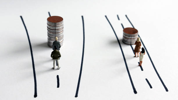 Concepts on the policy of gender discrimination in employment and wages. Miniature people and pile of coins. stock photo