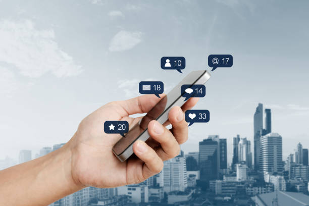 istock Hand holding mobile smart phone, with social media and social network notification icon 994076748