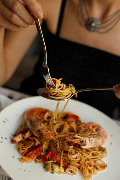 istock Woman eating seafood pasta 994078254