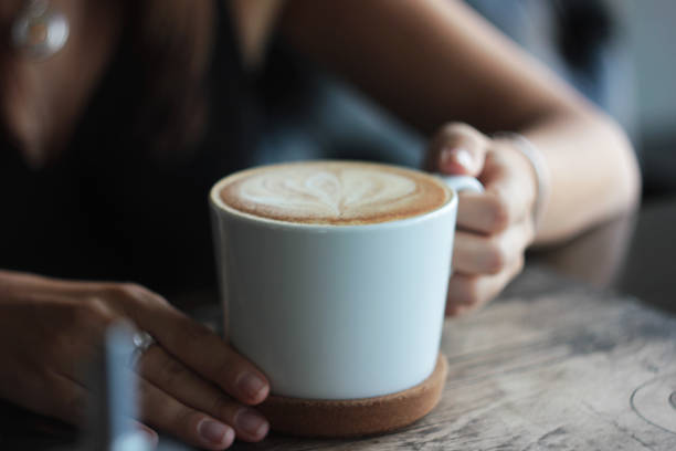 istock Large white Cup with cappuccino in female hands, selective focus 994087336