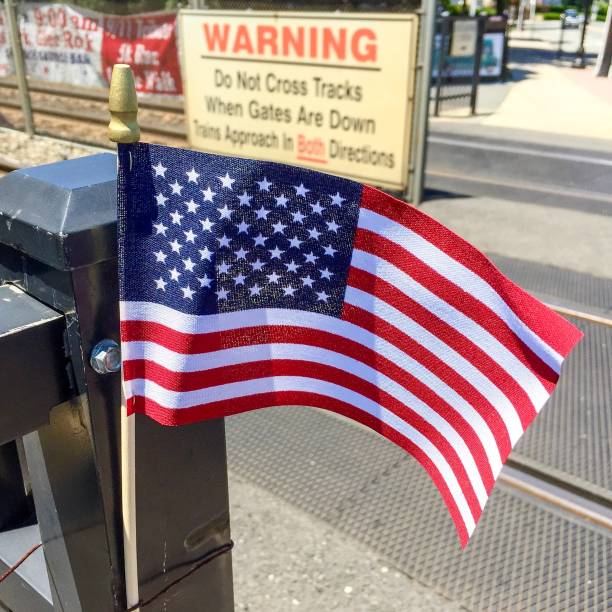 istock US flag and railroad warning sign 994099382