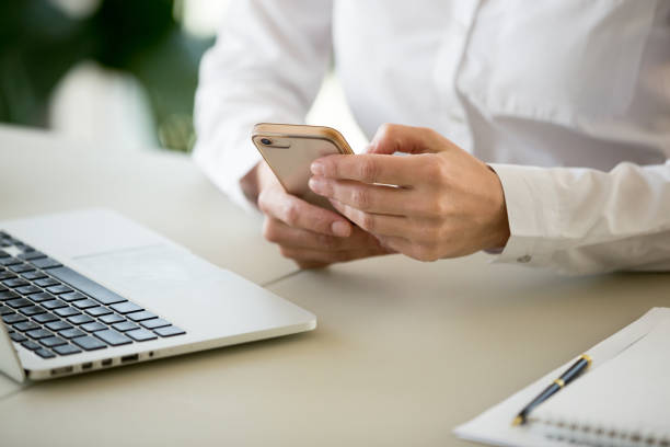 istock Businesswoman using business apps on smartphone working in office, closeup 994101680