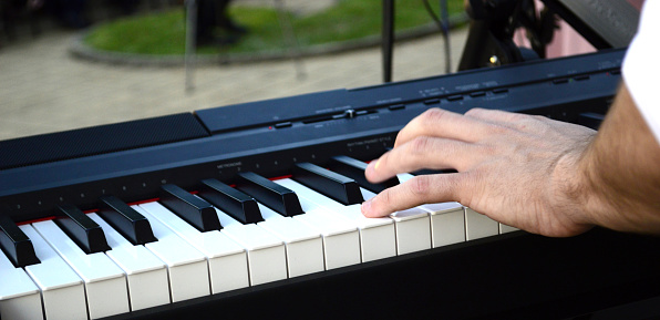 young musician playing synthesizer in an outdoor performance,image of a