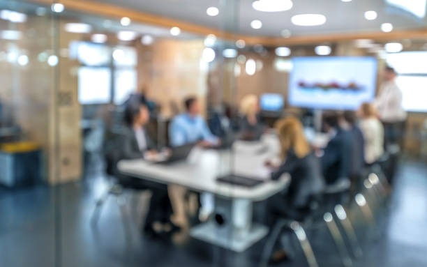 gens d’affaires de flou assis dans la salle de conférence - board room group of people business person clothing photos et images de collection