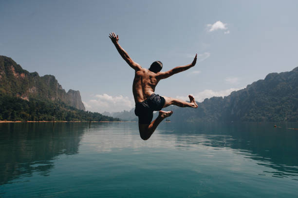 istock Man jumping with joy by a lake 994128352