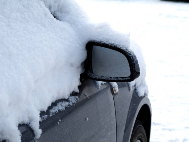 istock car covered with snow, focus on wing mirror 994129558