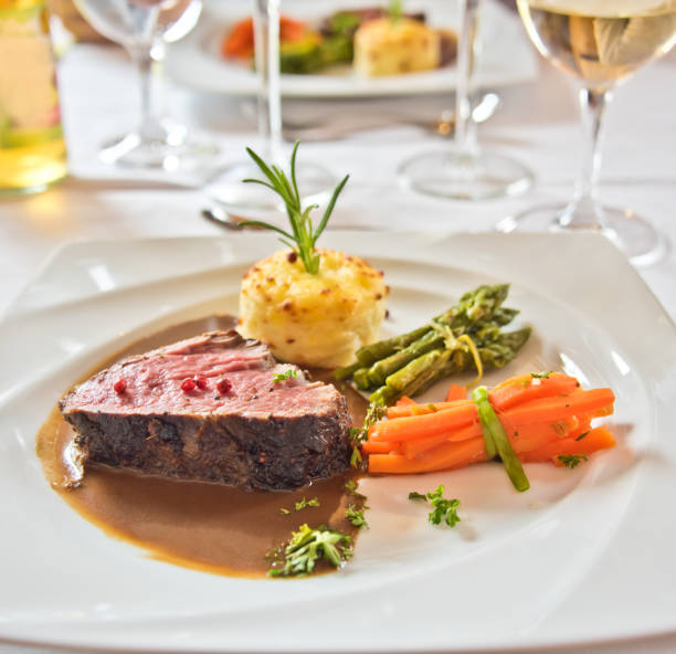 istock Roasted meat with carrots and asparagus on a white plate 994135866