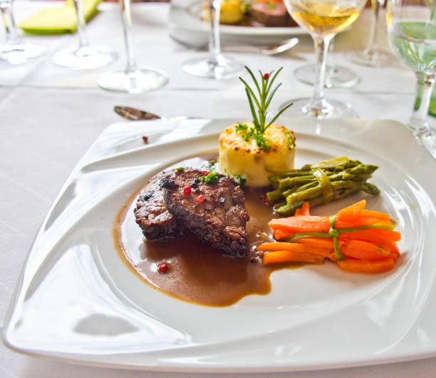 istock Roasted meat with carrots and asparagus on a white plate 994135926