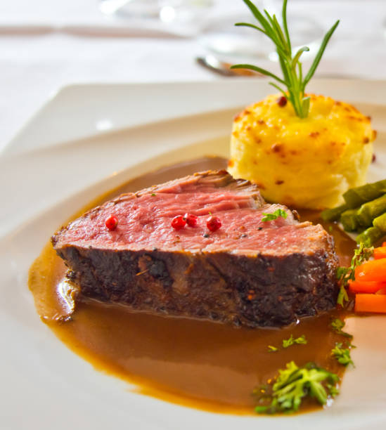 istock Roasted meat with carrots and asparagus on a white plate 994136186