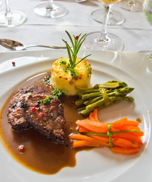 istock Roasted meat with carrots and asparagus on a white plate 994136214