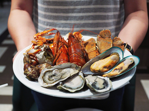 Plate of steamed crayfish, giant river prawn, mussel, giant crab and fresh oyster. Seafood buffet line.