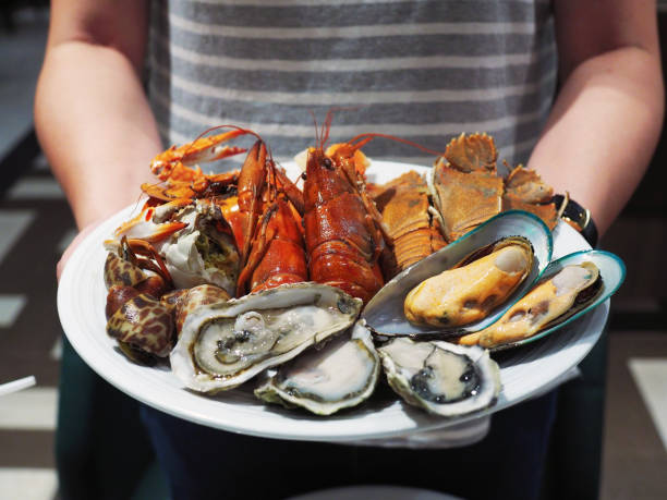 Plate of steamed crayfish, giant river prawn, mussel, giant crab and fresh oyster. Plate of steamed crayfish, giant river prawn, mussel, giant crab and fresh oyster. Seafood buffet line. arthropod stock pictures, royalty-free photos & images