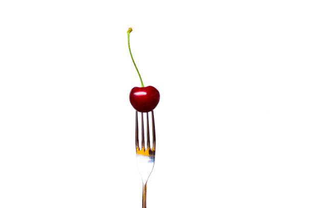 istock fresh red cherry blossom with green on a fork isolated on a white background - sweet eating, dessert and food concept 994136492