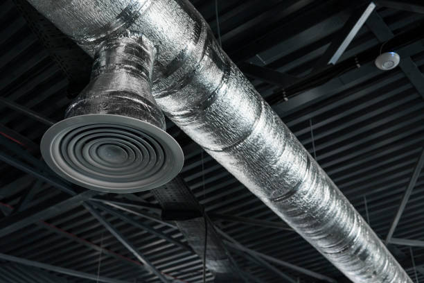 istock Ventilation system on the ceiling of large buildings. Ventilation pipes in silver insulation material hanging from the ceiling inside new building. 994143810