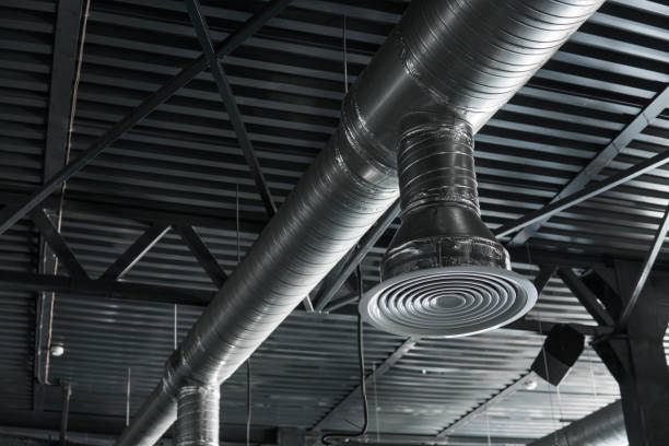 istock Ventilation system on the ceiling of large buildings. Ventilation pipes in silver insulation material hanging from the ceiling inside new building. 994144034