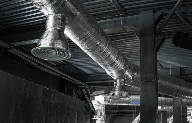 istock Ventilation system on the ceiling of large buildings. Ventilation pipes in silver insulation material hanging from the ceiling inside new building. 994144544