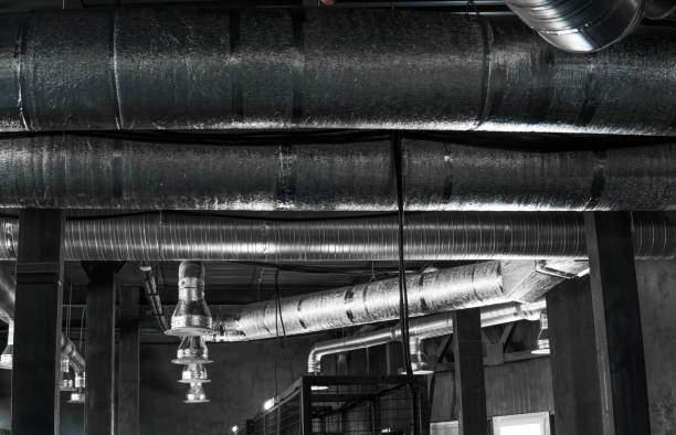 istock Ventilation system on the ceiling of large buildings. Ventilation pipes in silver insulation material hanging from the ceiling inside new building. 994145044